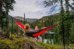 woman relaxing in hammock in the woods