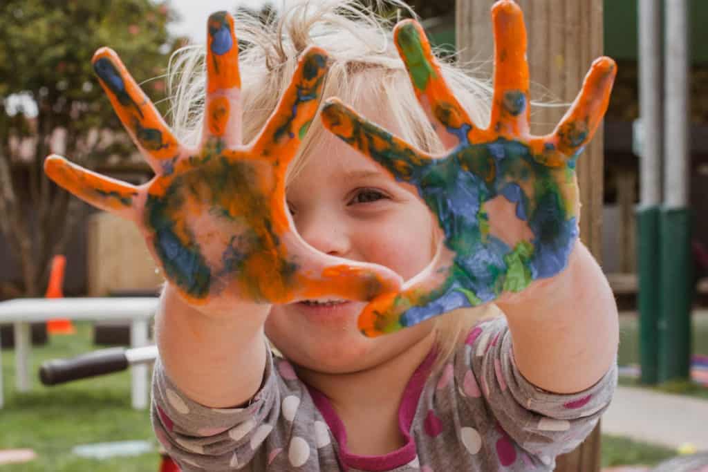 Child at home playing with finger paint