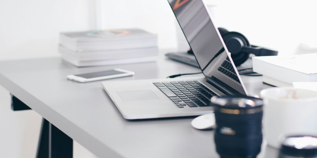 silver MacBook Pro on white table