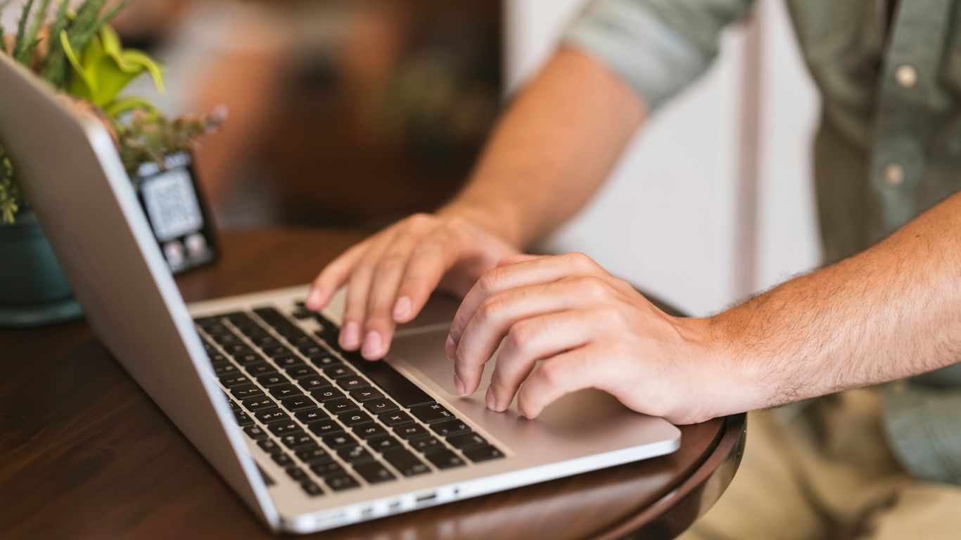 a man typing on a laptop