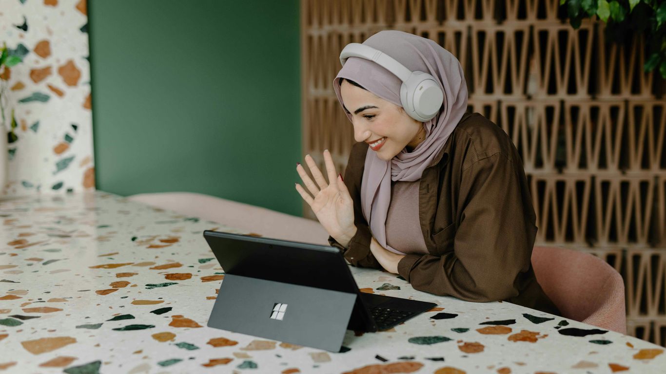 a person sitting on a table with a laptop