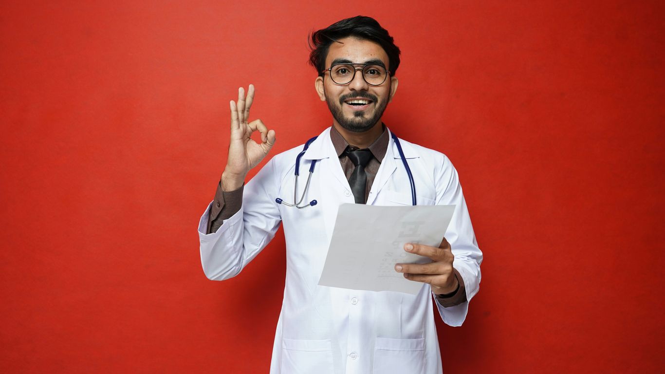 a man in a white coat holding a piece of paper