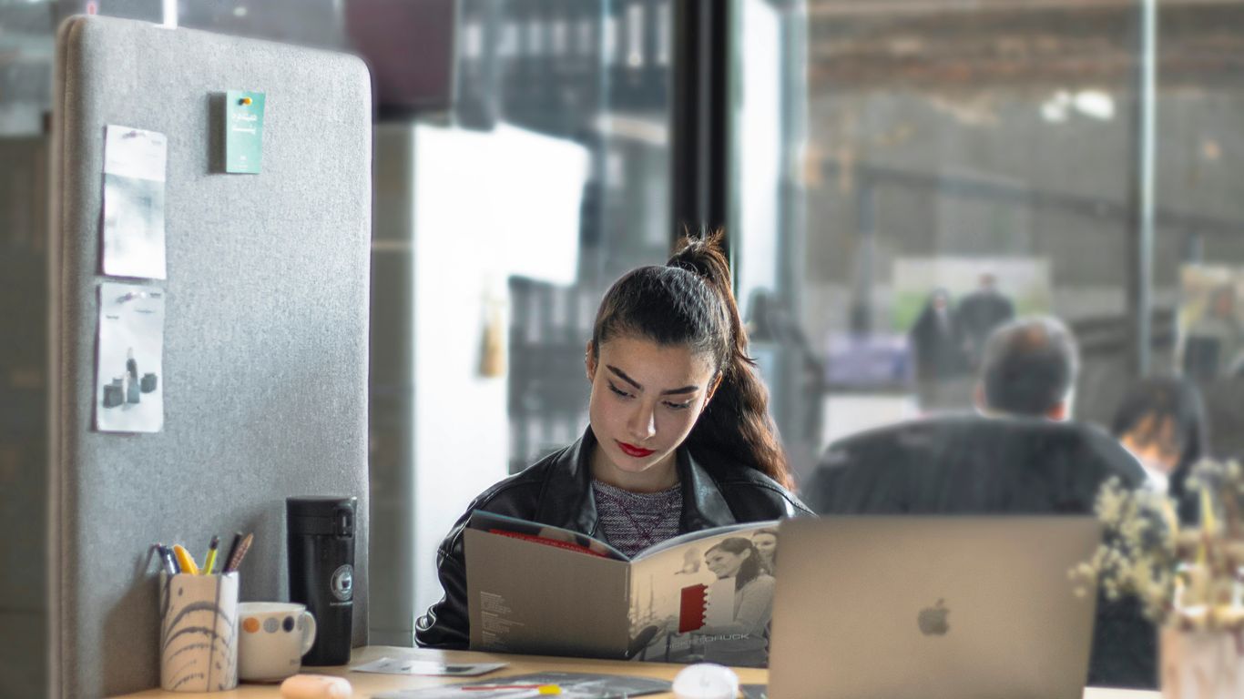 a woman sitting at a table with a laptop