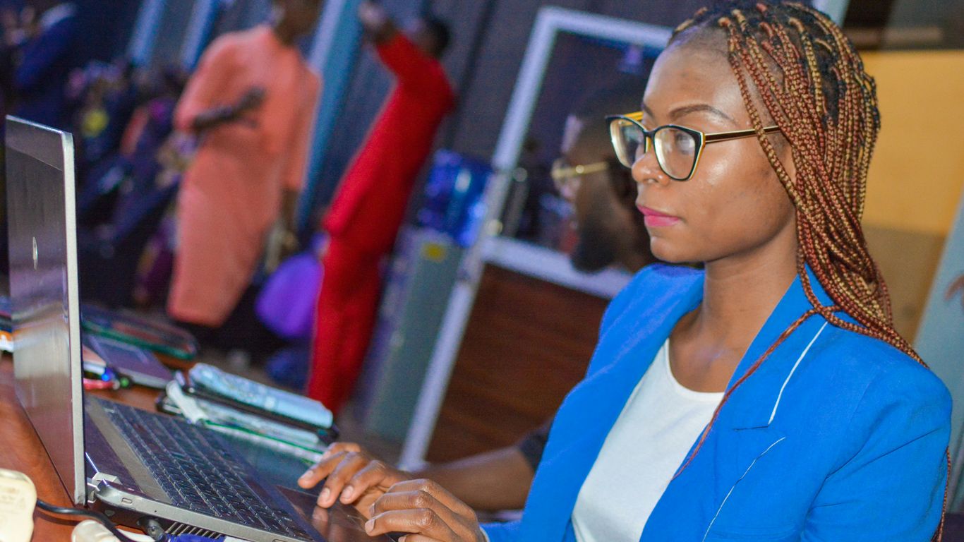 a woman sitting in front of a laptop computer