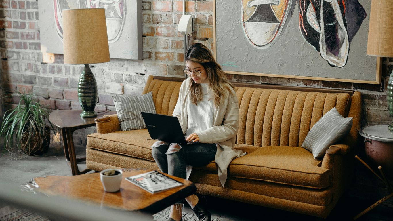 woman using laptop while sitting on chair