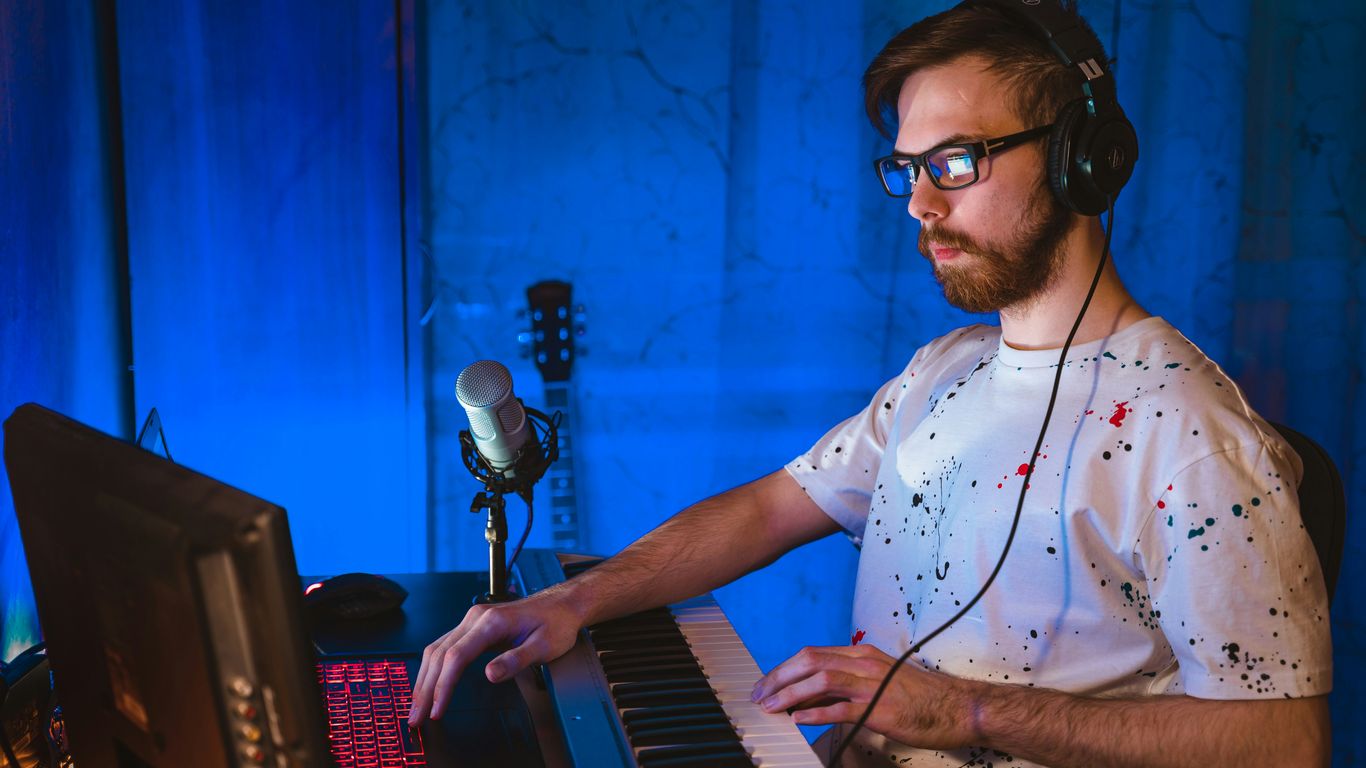 man in blue and white polka dot button up shirt playing electric keyboard